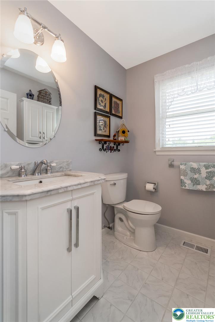 1795 Freier Road Quakertown, PA 18951 - Photo 21 of 69 An updated powder room offers a vanity with marble countertops and a large circular mirror.