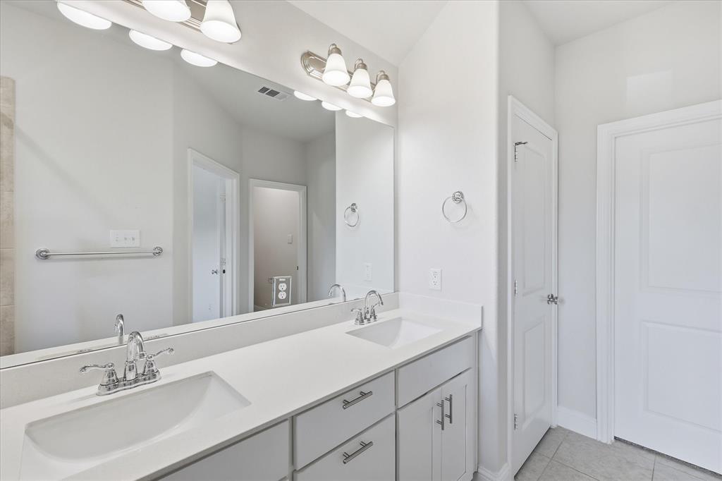 519 Sequoia Street Allen, TX 75002 - Photo 25 of 38 Bathroom featuring a double vanity with white countertops and integrated sinks, brushed chrome faucets, and cabinet storage