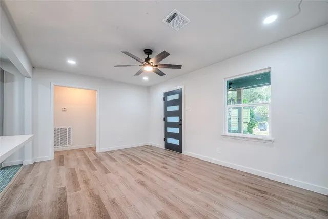 a view of a big room with wooden floor and windows
