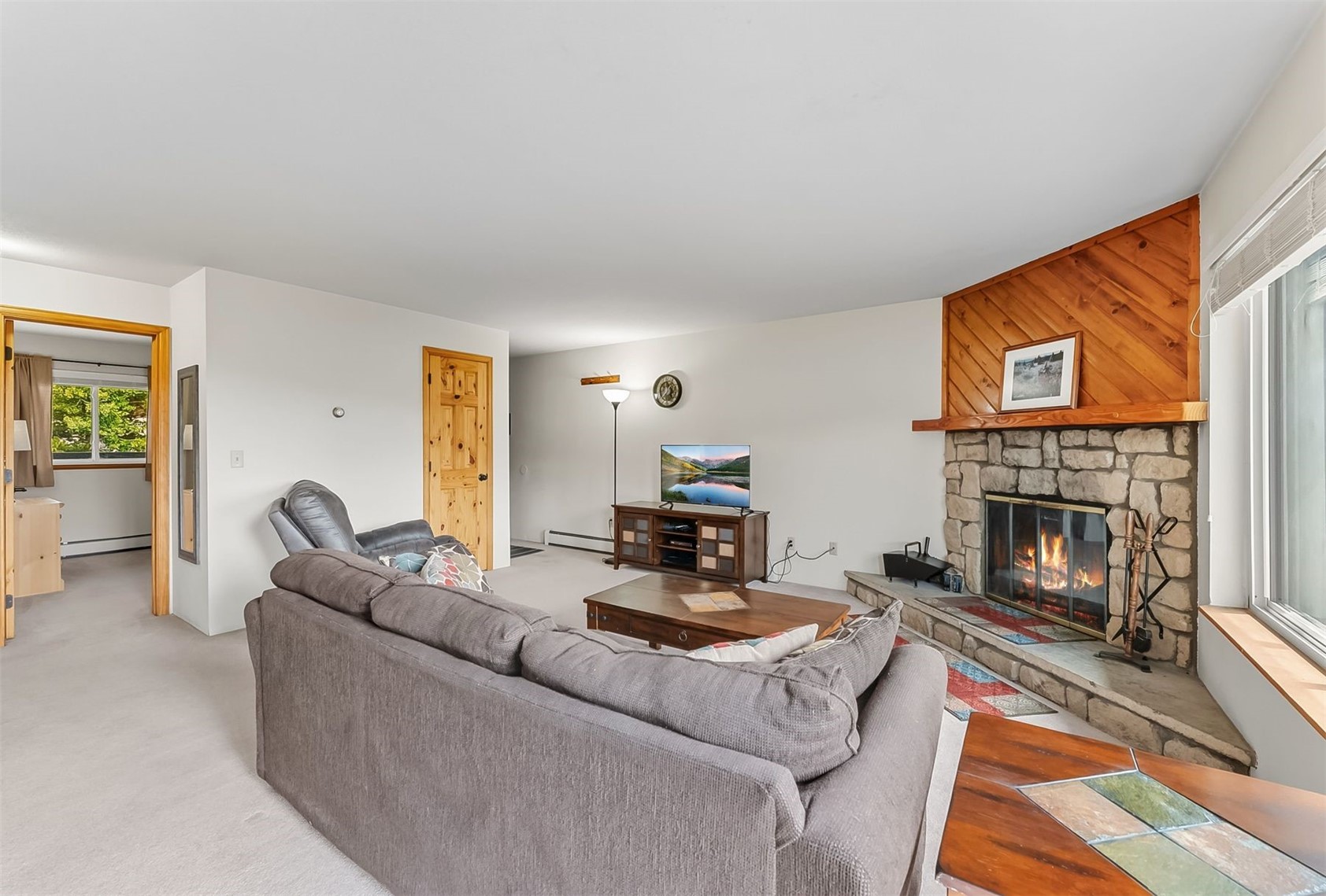 9849 Ryan Gulch Road, Unit 203 Silverthorne, CO 80498 - Photo 9 of 35 Carpeted living room with a fireplace and a baseboard radiator