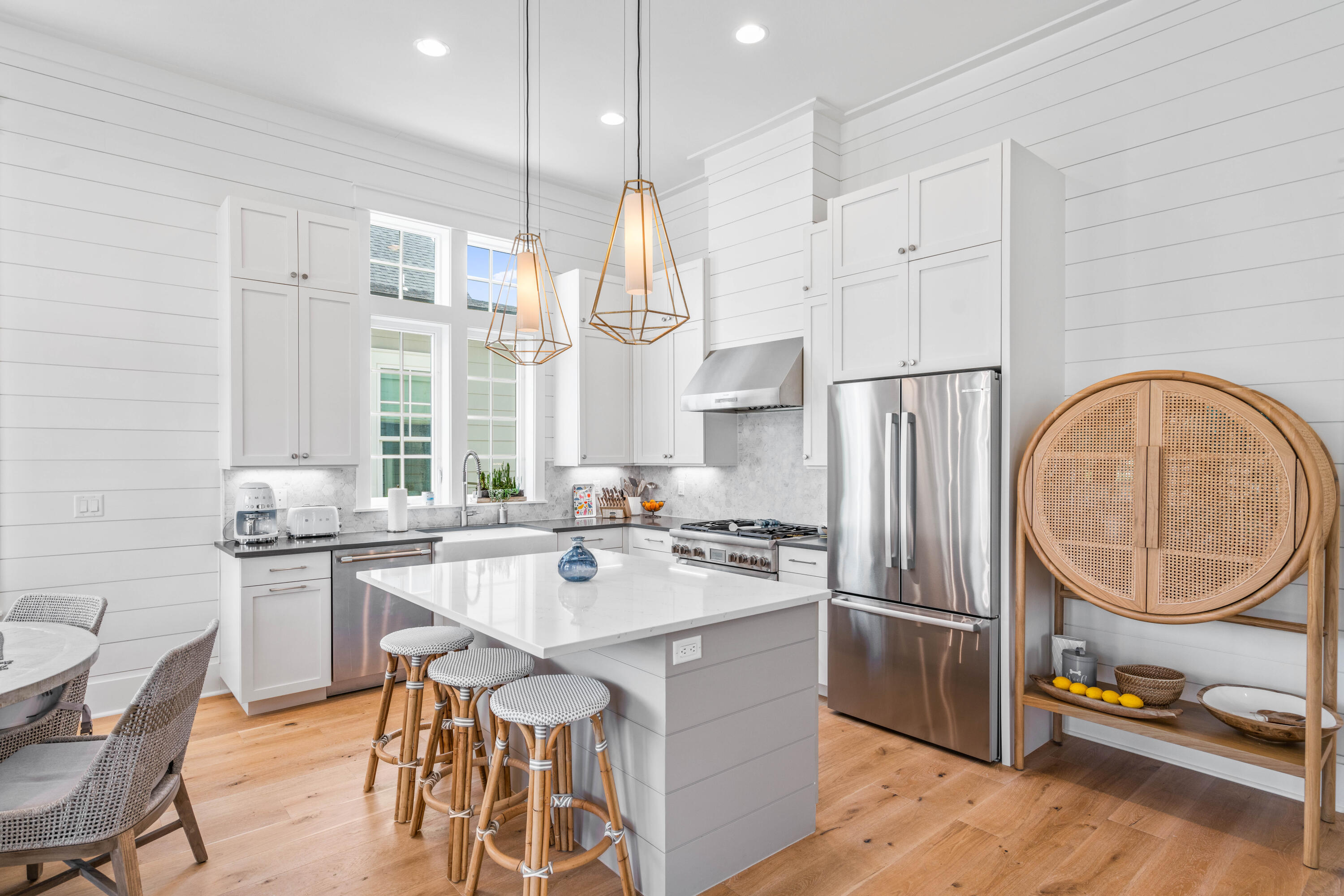 888 Pathways Dr Inlet Beach Inlet Beach, FL 32461 - Photo 14 of 43 a kitchen with stainless steel appliances granite countertop a stove a refrigerator a sink a dining table and chairs with wooden floor