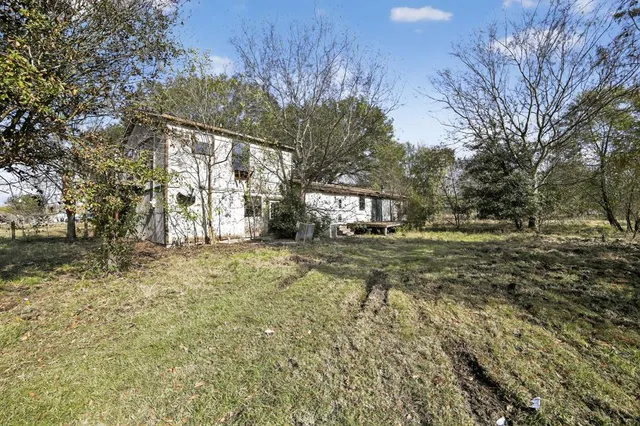 a view of house with backyard and trees
