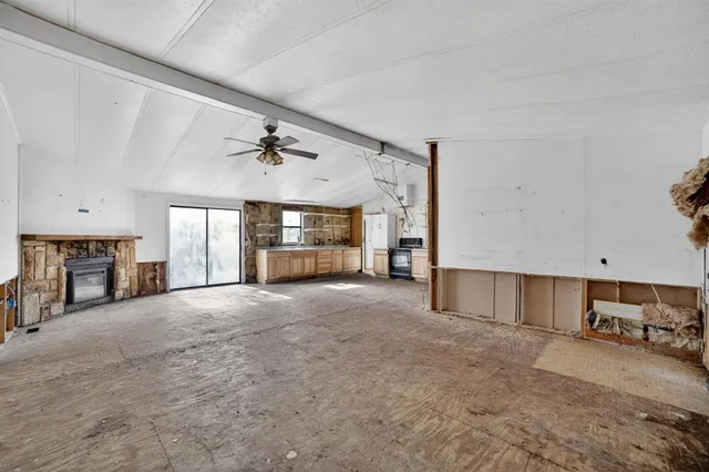 a view of a livingroom with fireplace and window