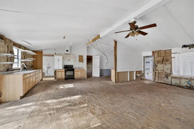 a view of a kitchen with furniture a ceiling fan and window