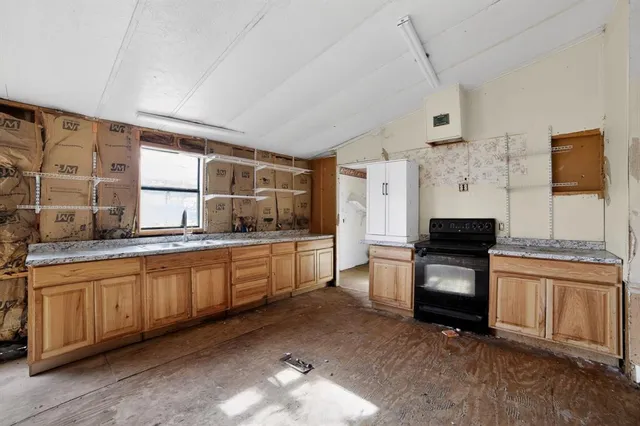a open kitchen with stainless steel appliances granite countertop a stove and a sink