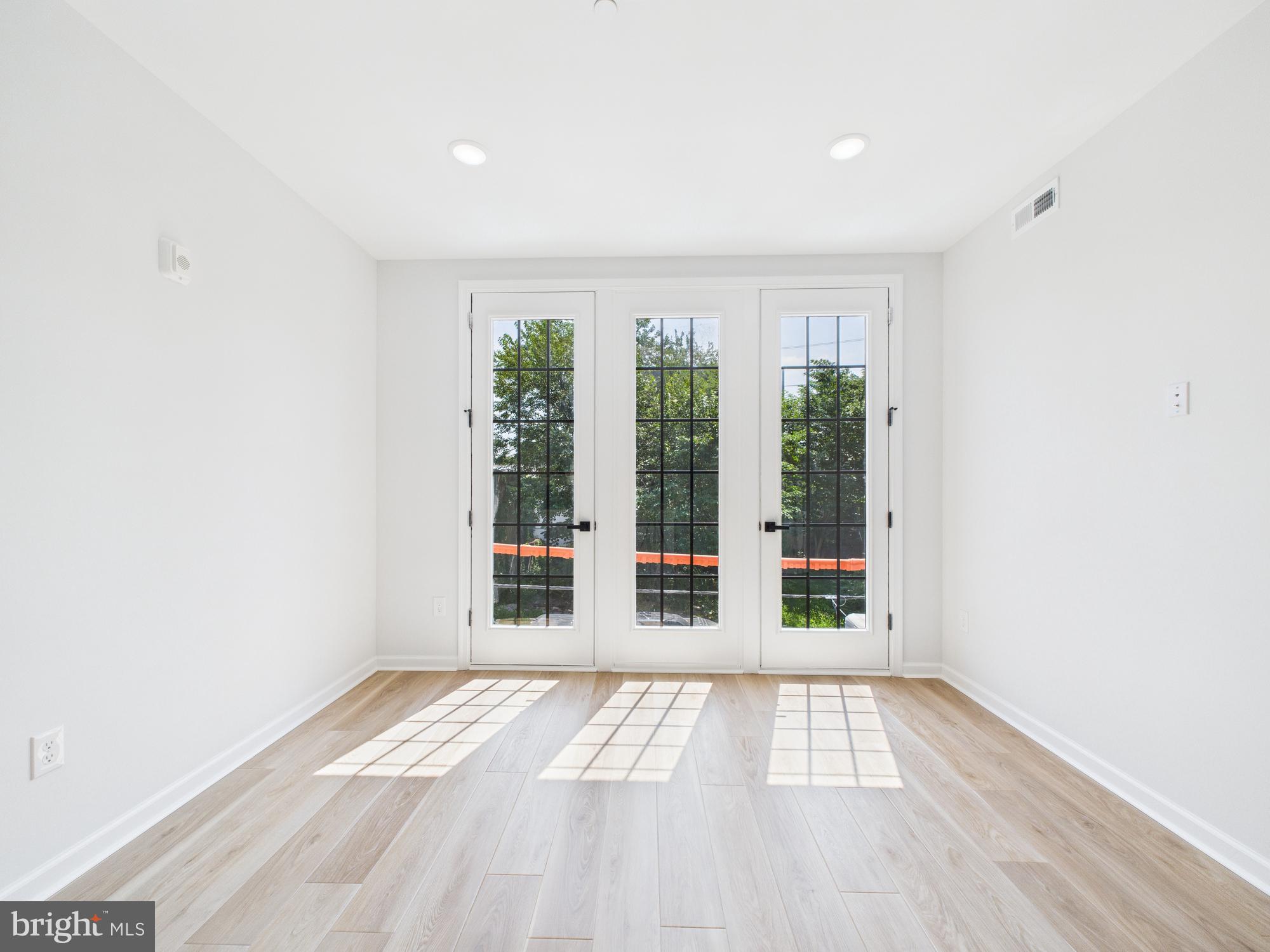 1326 Grove Street, Unit 4 Philadelphia, PA 19146 - Photo 2 of 14 a view of empty room with wooden floor and windows