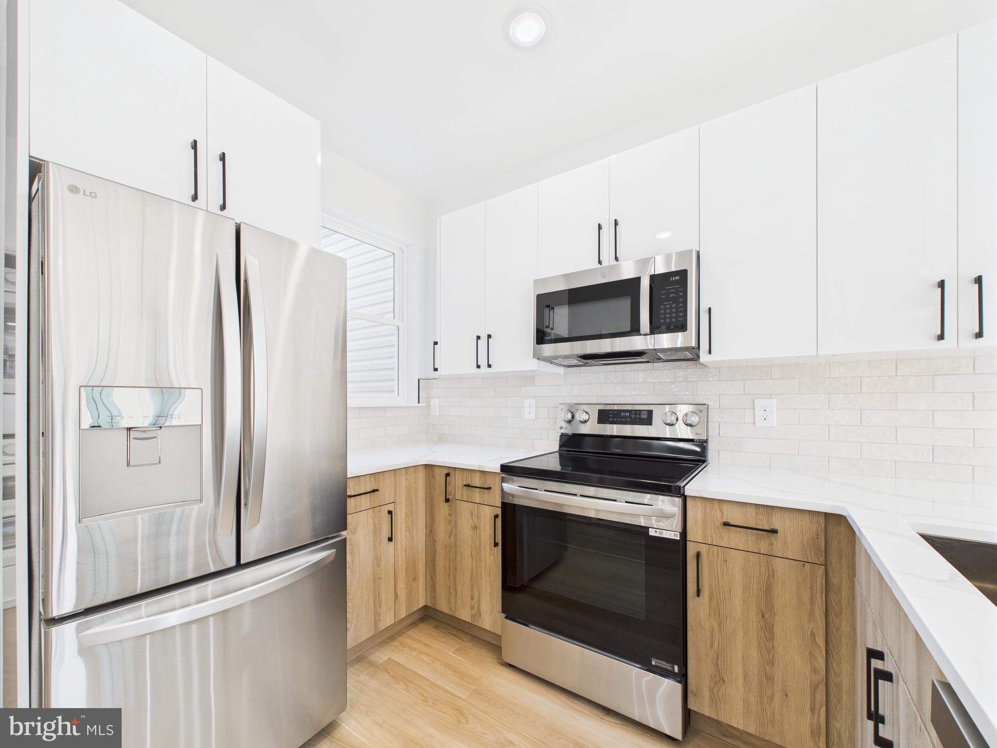 1326 Grove Street, Unit 4 Philadelphia, PA 19146 - Photo 5 of 14 a kitchen with stainless steel appliances a stove a refrigerator and a microwave