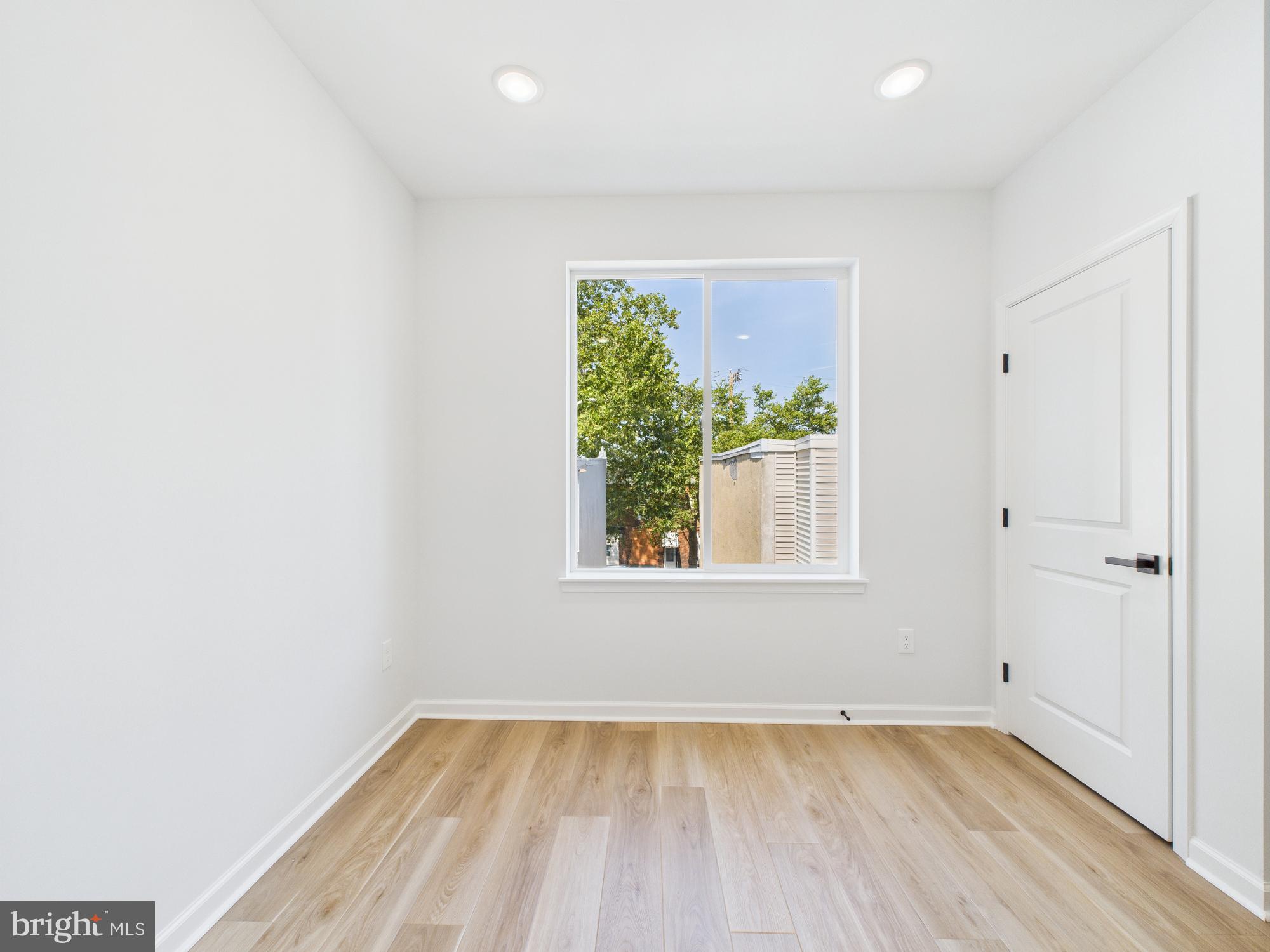 1326 Grove Street, Unit 4 Philadelphia, PA 19146 - Photo 9 of 14 an empty room with wooden floor and windows
