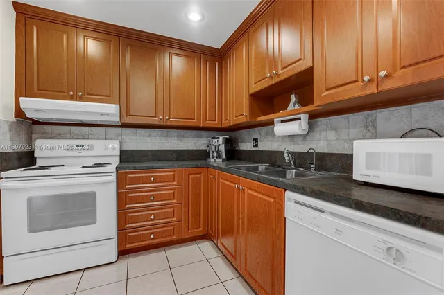 a kitchen with granite countertop cabinets stainless steel appliances and a sink