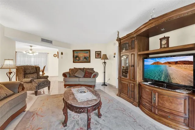 a living room with furniture a flat screen tv and large window