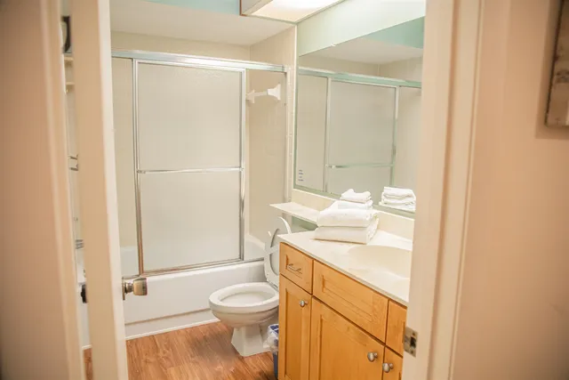 a bathroom with a granite countertop sink toilet and shower