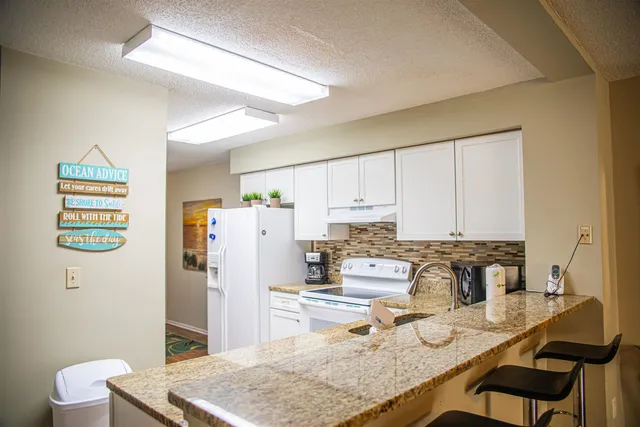 a kitchen with stainless steel appliances granite countertop a sink refrigerator and microwave