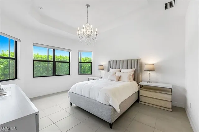 a bedroom with a large bed and a chandelier