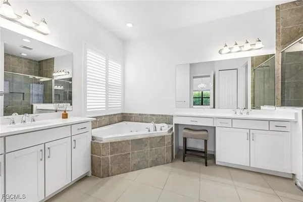 a spacious bathroom with a double vanity sink mirror and bathtub