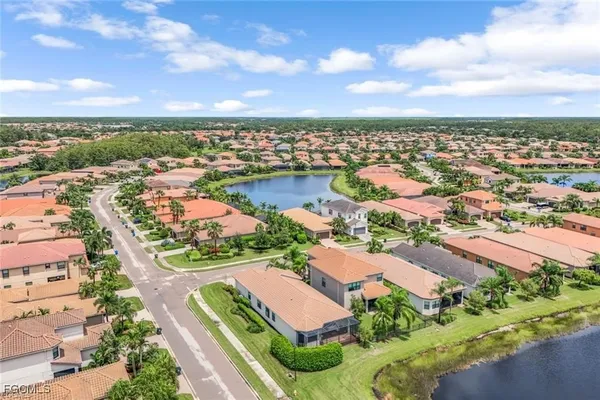 an aerial view of residential houses with outdoor space and ocean