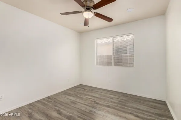 an empty room with a window and a ceiling fan