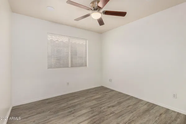 an empty room with a window and a ceiling fan
