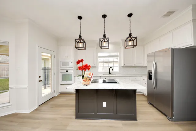a kitchen with kitchen island a sink stainless steel appliances and cabinets