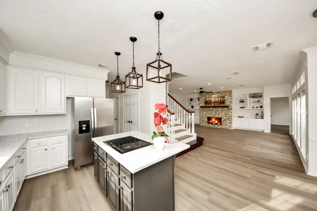 a kitchen that has a lot of white cabinets and stainless steel appliances