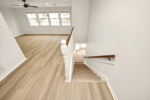 a view of a livingroom with a ceiling fan and wooden floor