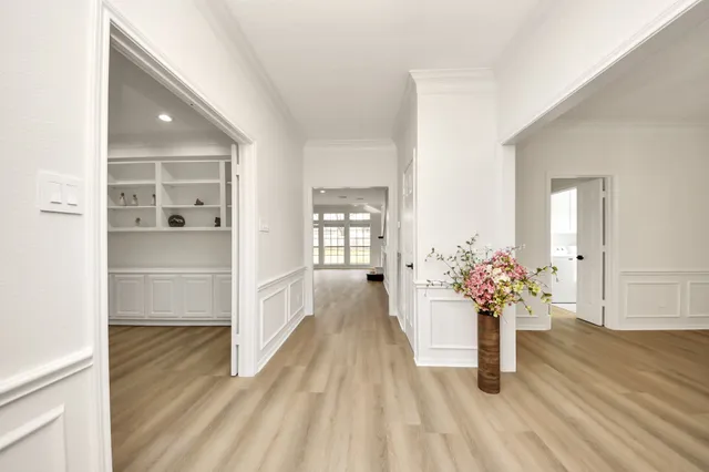 a view of a hallway with wooden floor and a living room