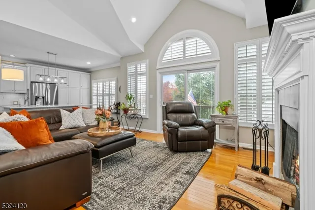 a living room with fireplace furniture and a large window