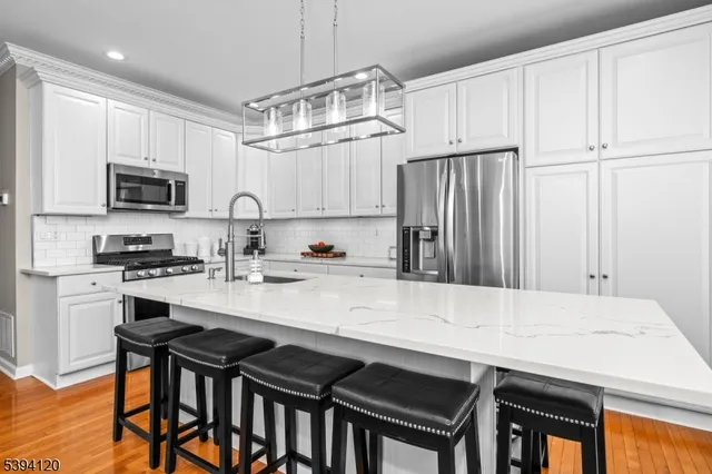 a kitchen with kitchen island a stove a table and chairs in it