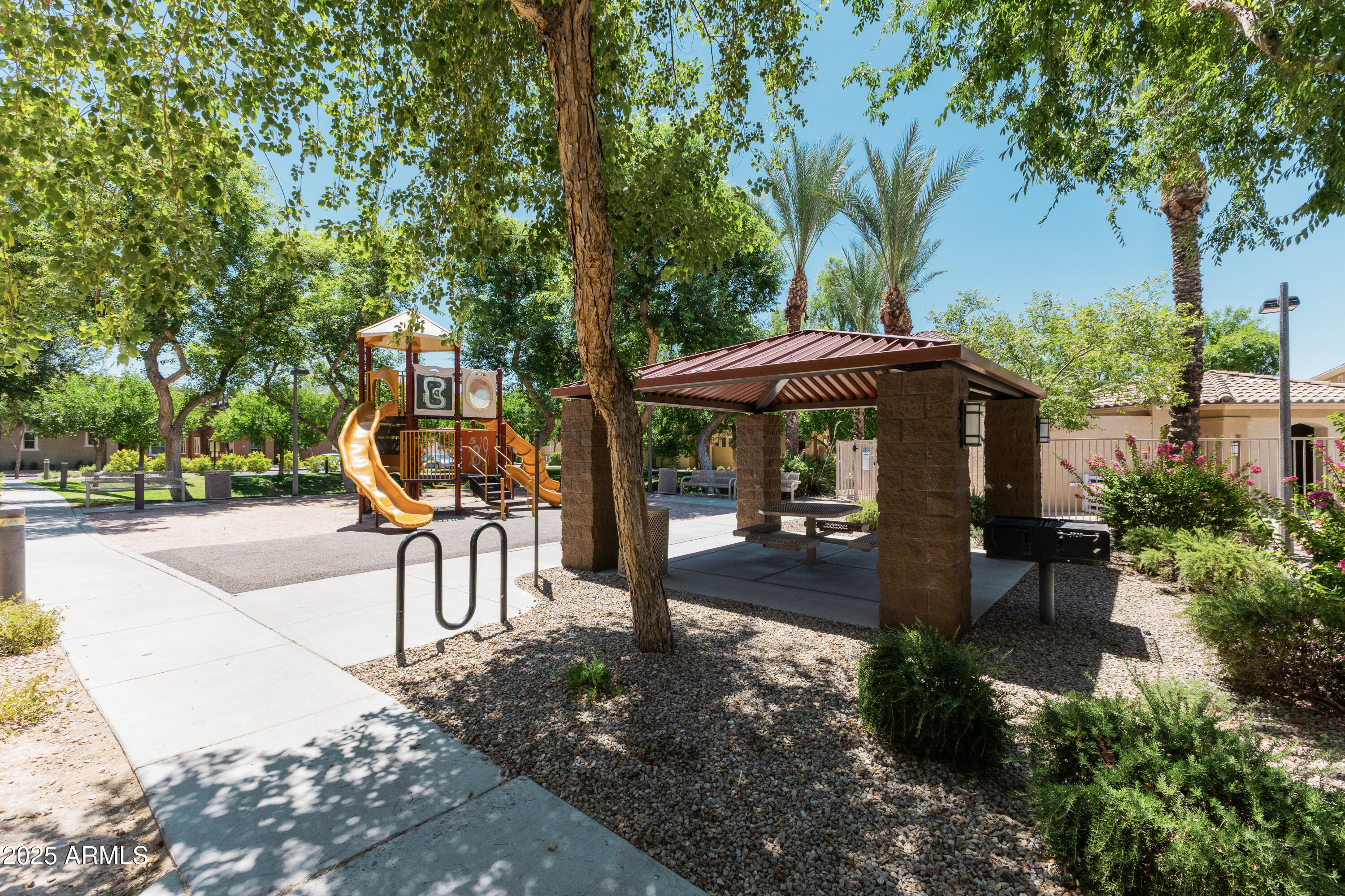451 South Hawes Road, Unit 53 Mesa, AZ 85208 - Photo 35 of 37 a view of a patio with a table and chairs under an umbrella