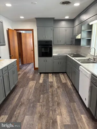a kitchen with granite countertop a stove top oven and cabinets