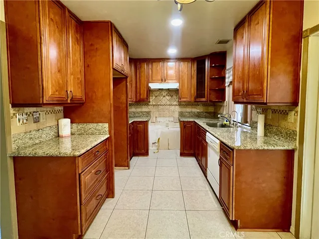 a kitchen with stainless steel appliances granite countertop wooden cabinets a sink and dishwasher