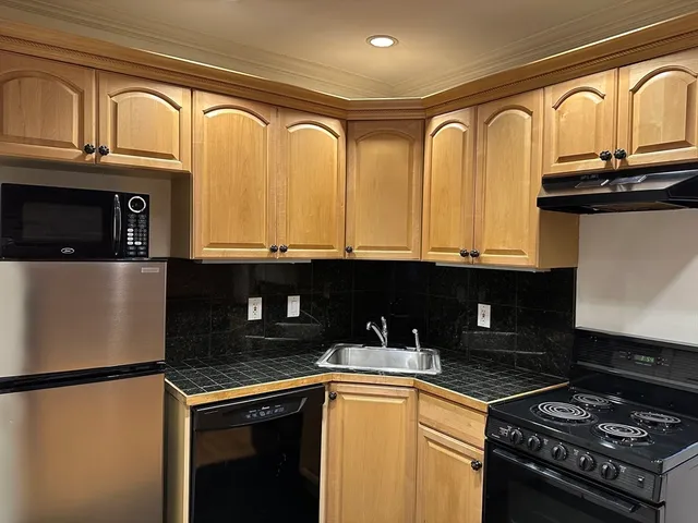 a kitchen with granite countertop a stove and a refrigerator