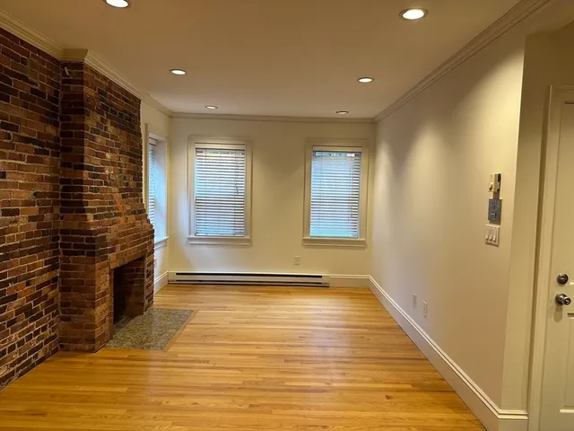 a view of an empty room with a fireplace and a window