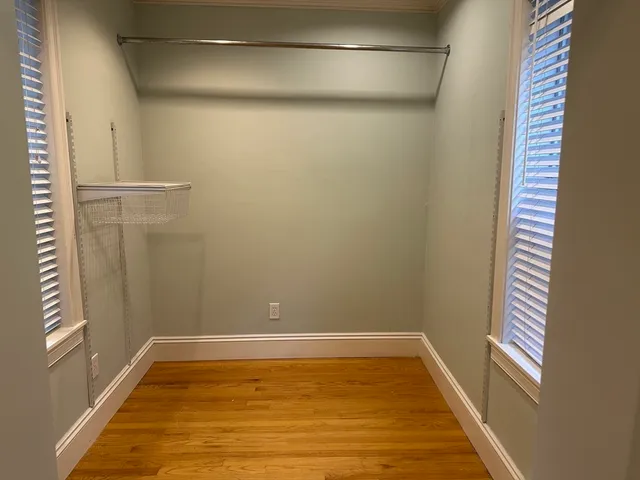 a view of a room with wooden floor and small window