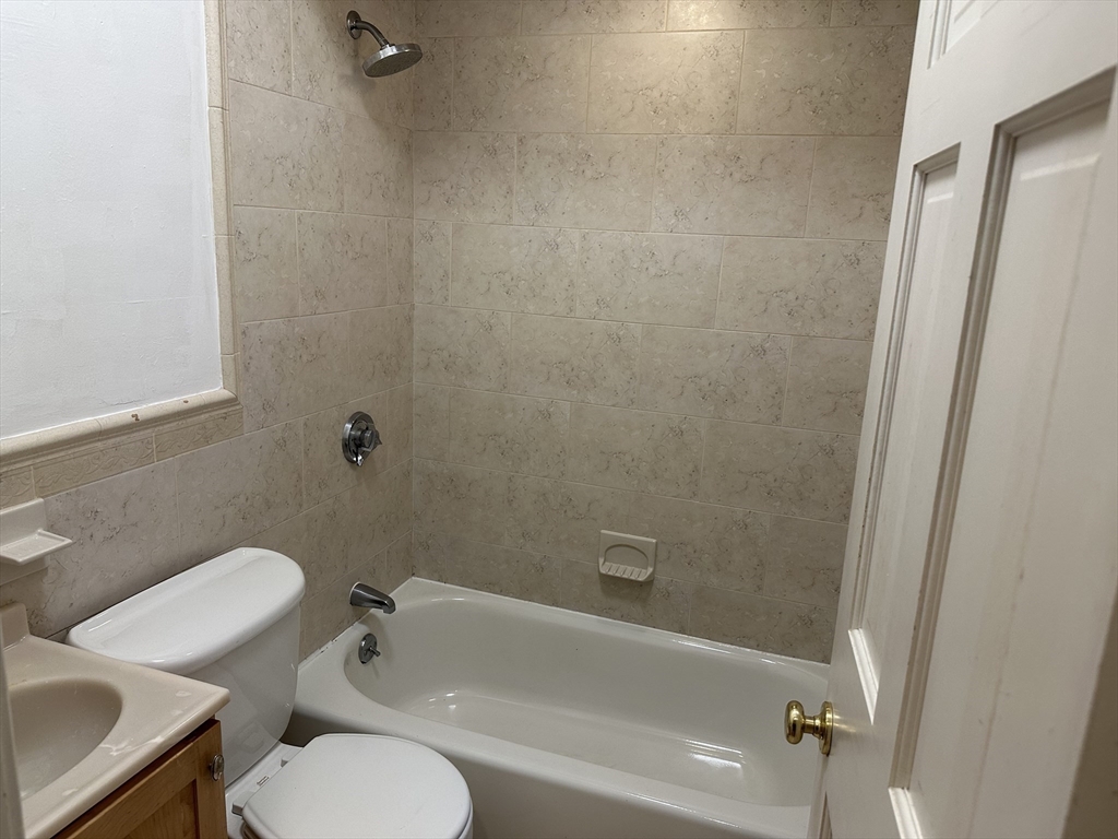1 Hull St Court, Unit 4 Boston, MA 02113 - Photo 6 of 10 a white toilet and tub sitting next to a bathroom sink