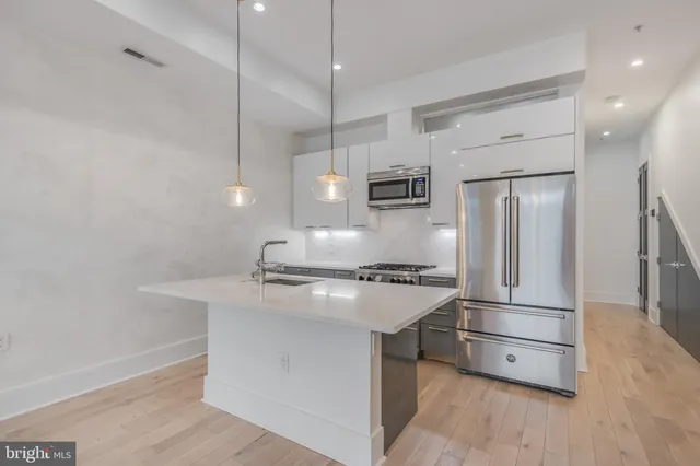 a kitchen with stainless steel appliances a sink a stove and a refrigerator