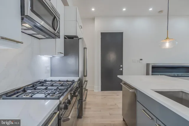 a view of a kitchen with a sink and chandelier