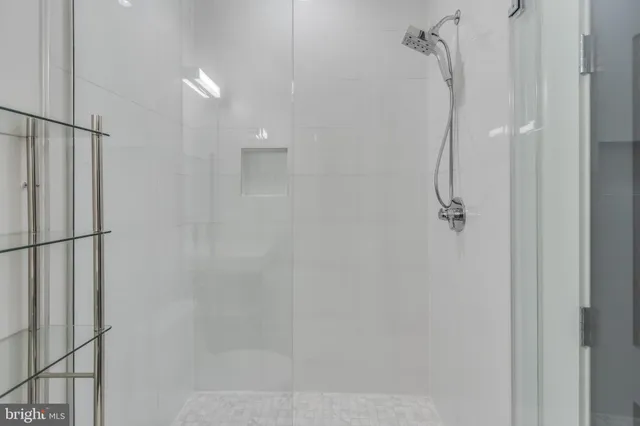 a view of a hallway with wooden floor and a bathroom