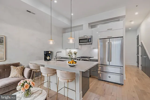 a kitchen with stainless steel appliances granite countertop a refrigerator sink and a stove