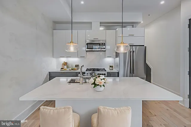 a kitchen with stainless steel appliances granite countertop a sink a stove a refrigerator and island