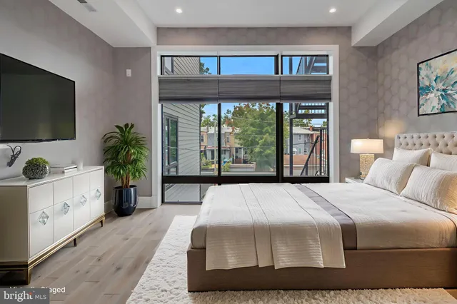a bedroom with a large bed and a flat tv screen on the dresser