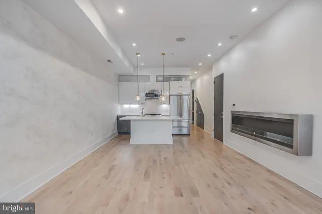 a kitchen with kitchen island a stove a refrigerator and wooden floor