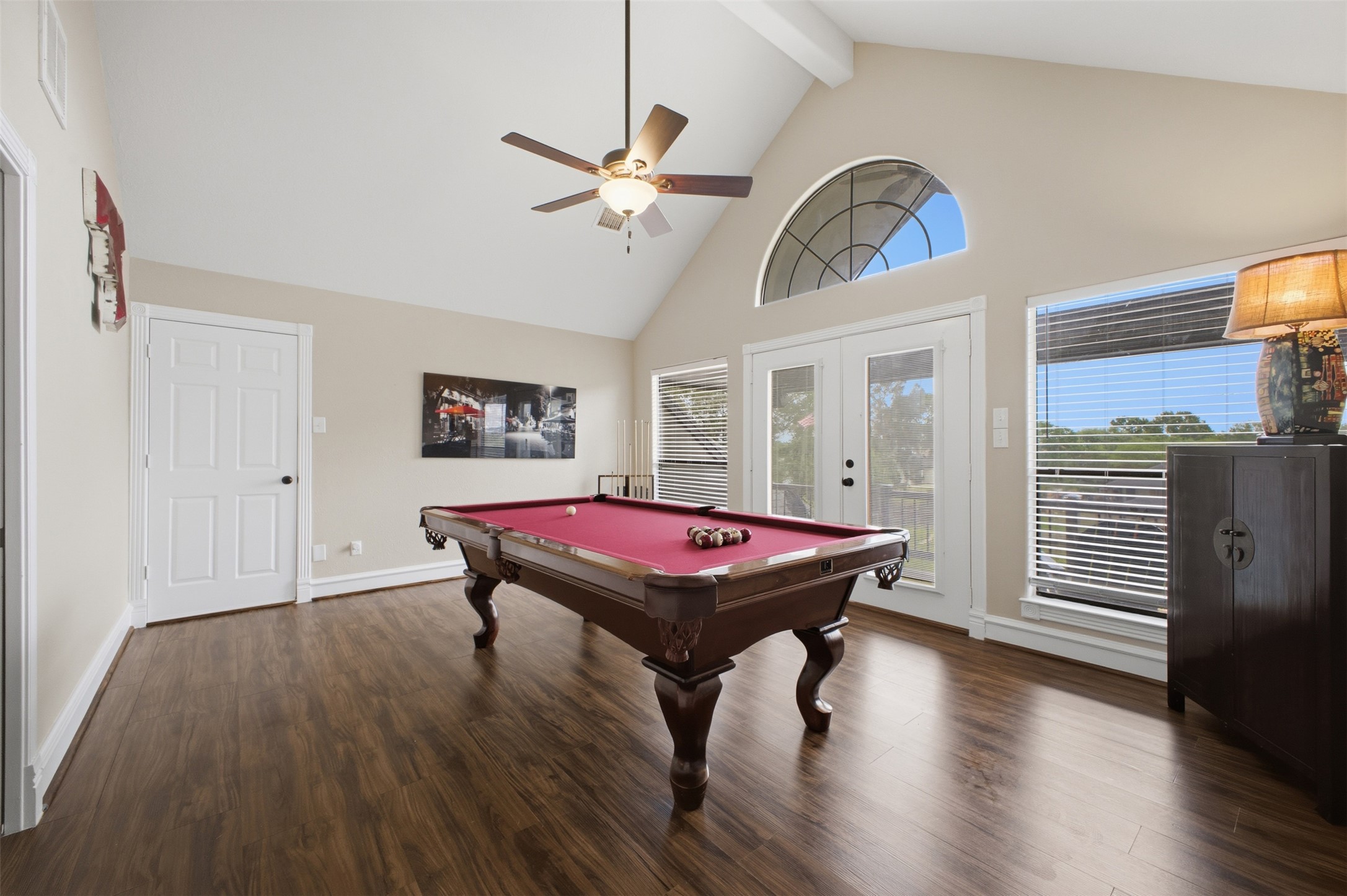 12710 Aries Loop Willis, TX 77318 - Photo 30 of 40 This room features a vaulted ceiling with exposed beams, hardwood flooring, and large windows with blinds