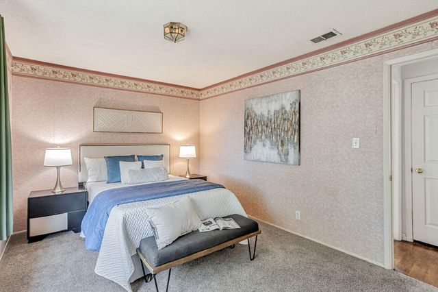 a bedroom with a bed and a painting on the wall