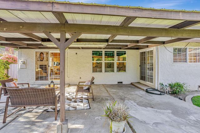 a view of a house with backyard sitting area and garden