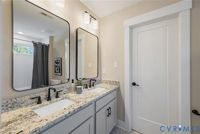 a bathroom with a granite countertop sink vanity and mirror