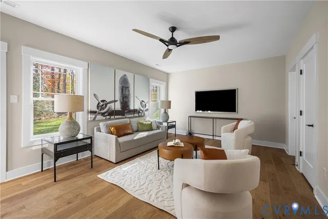 a living room with furniture flat screen tv and a window