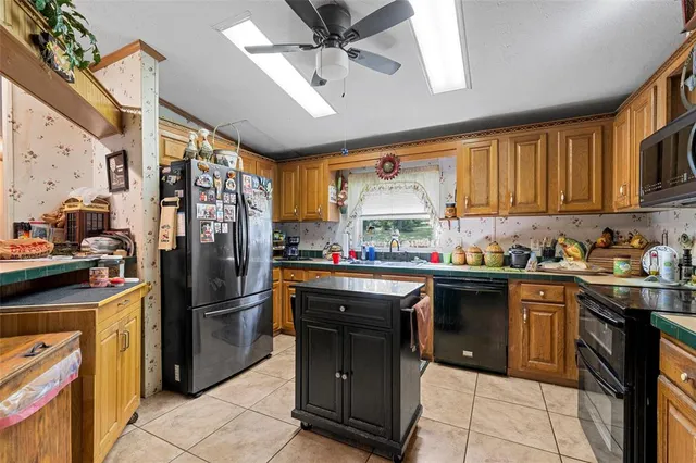 a kitchen with stainless steel appliances granite countertop a refrigerator a sink dishwasher a stove and a refrigerator
