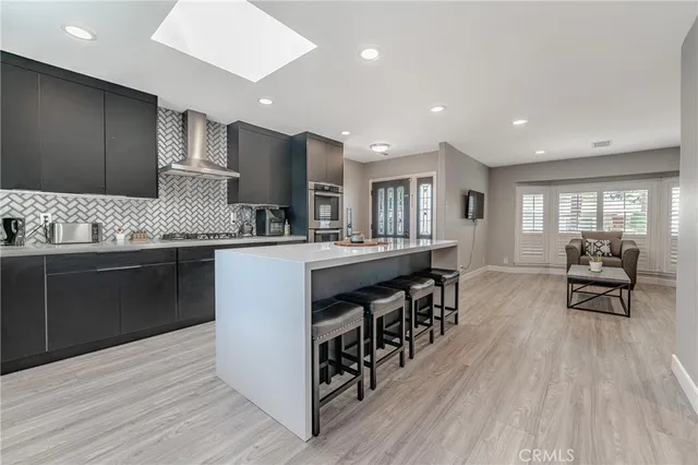 a kitchen with stainless steel appliances granite countertop a stove and a wooden floors