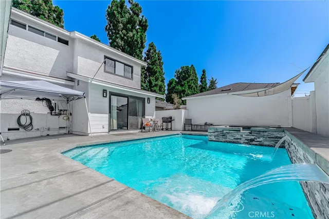 a view of a house with pool and a yard