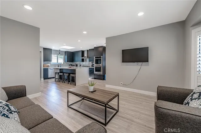 a living room with kitchen furniture and a flat screen tv